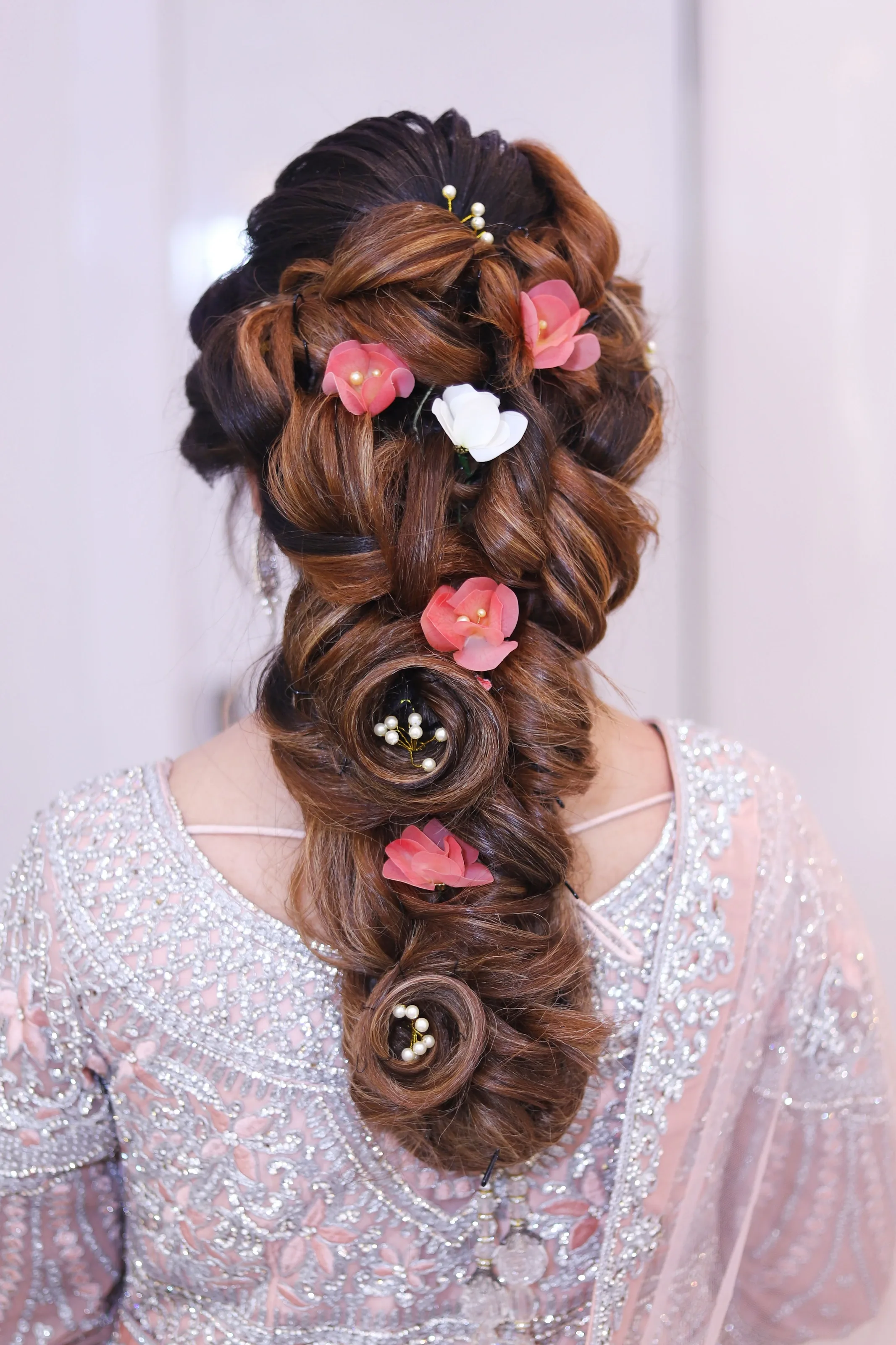 Long bridal braid decorated with pink roses
