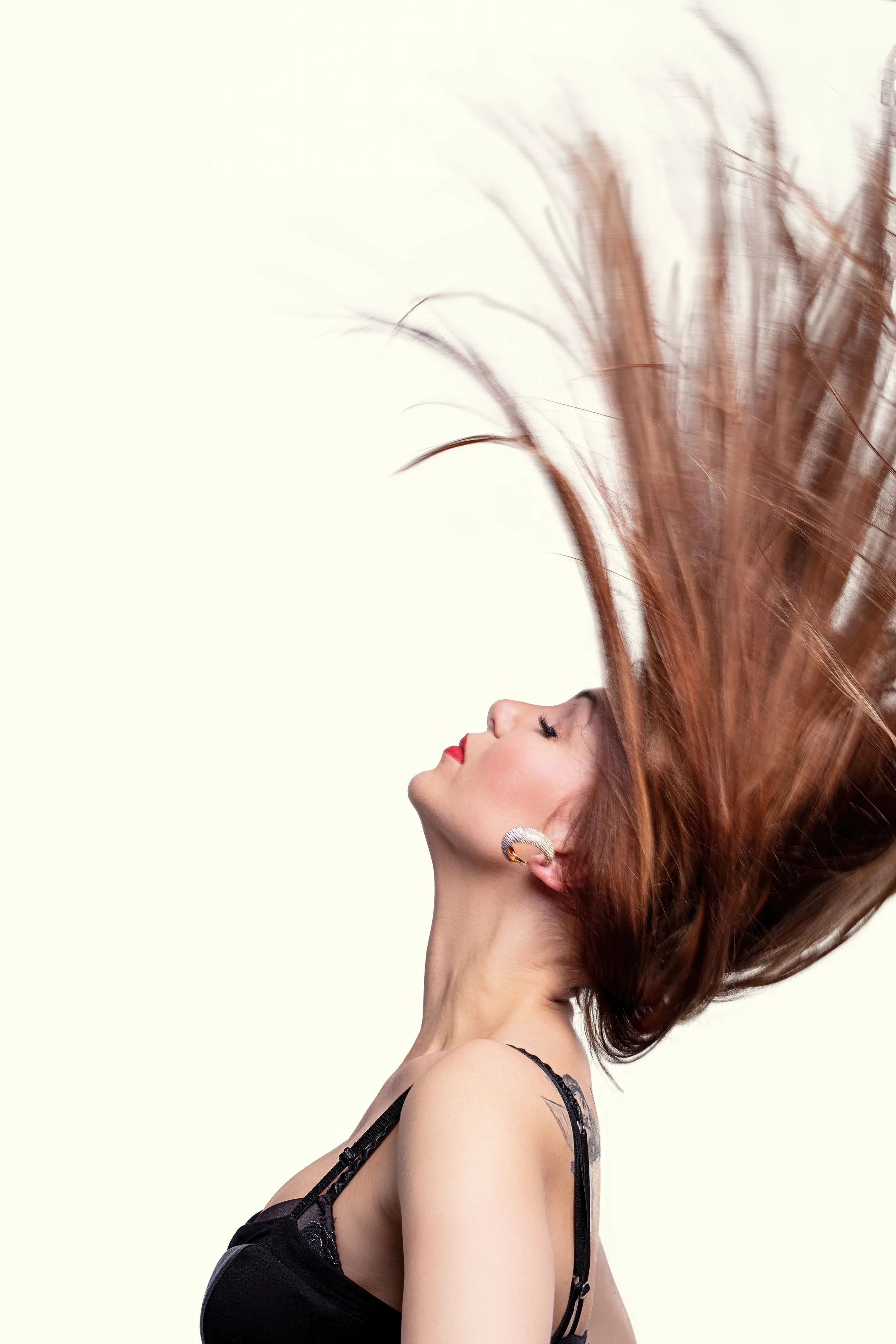 Woman tossing her long auburn hair mid-motion